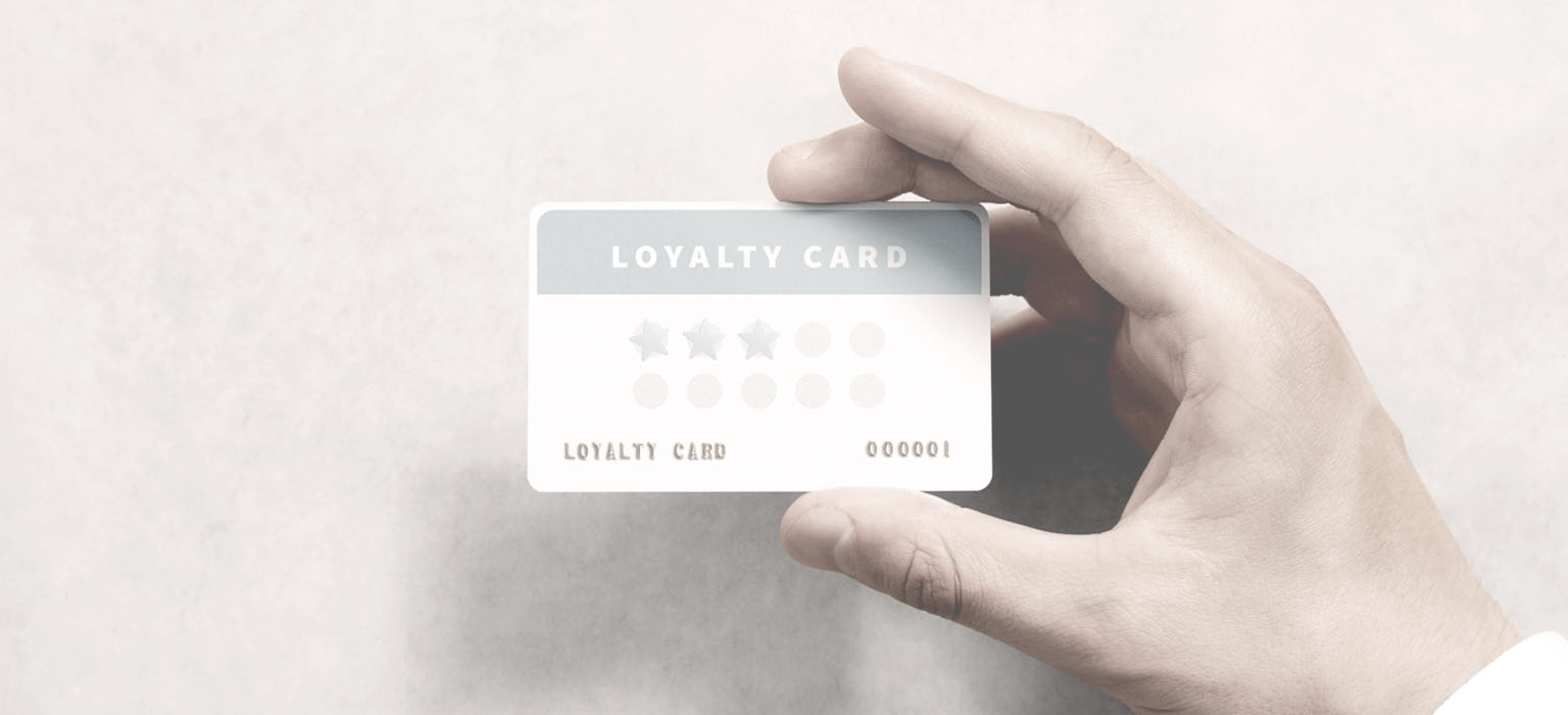 A man holds a brand loyalty card in his hand