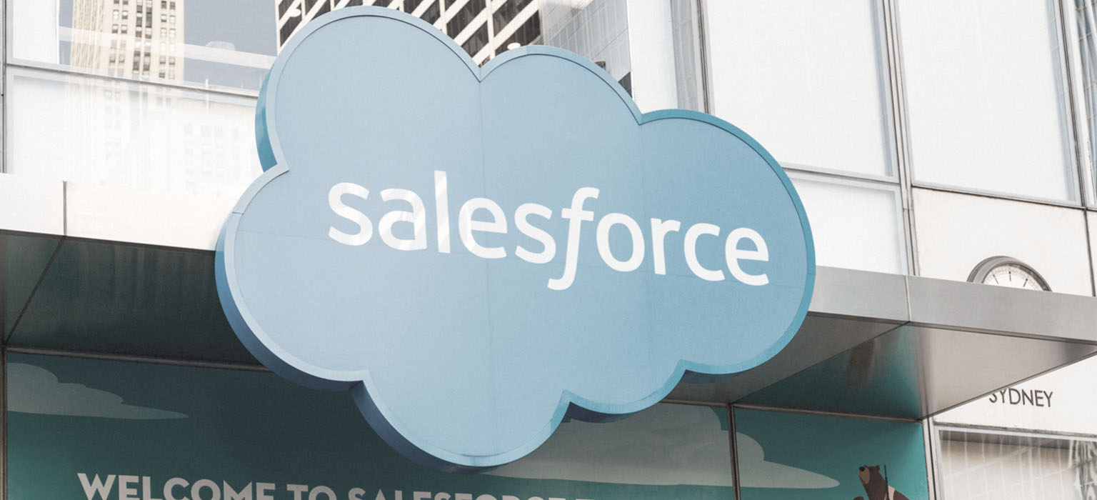 The Salesforce sign hangs outside an office building 