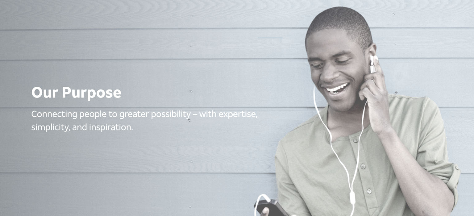 A man smiles and listens to earphones alongside AT&T's purpose statement